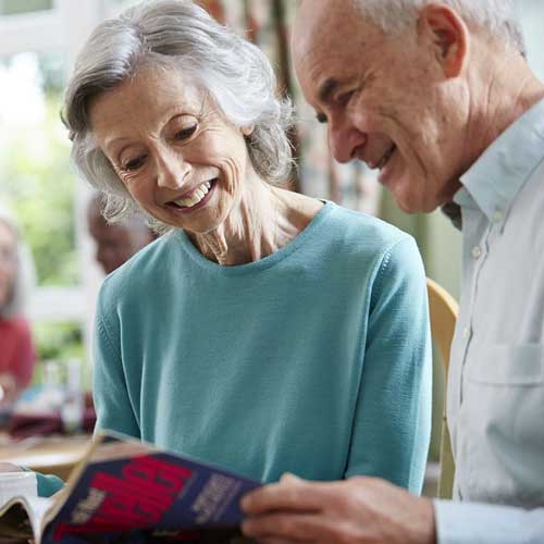 Elderly couple looking at a magazine